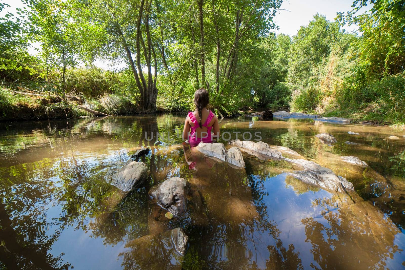 Child girl discovering Gevora river, La Codosera, Badajoz, Extremadura, Spain. Idyllic location of crystal clear waters and riverside forests