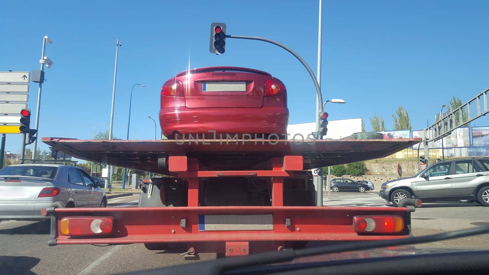 Driving on city behind a slow tow truck. View from the inside of the car