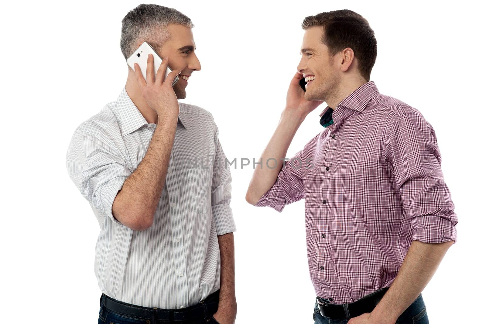 Two young friends happily talking on mobile phone