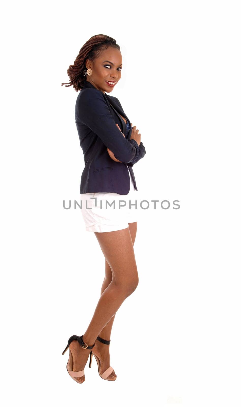 A lovely slim young African American woman in a dark blue jacket and white.shorts, looking into camera, isolated for white background..