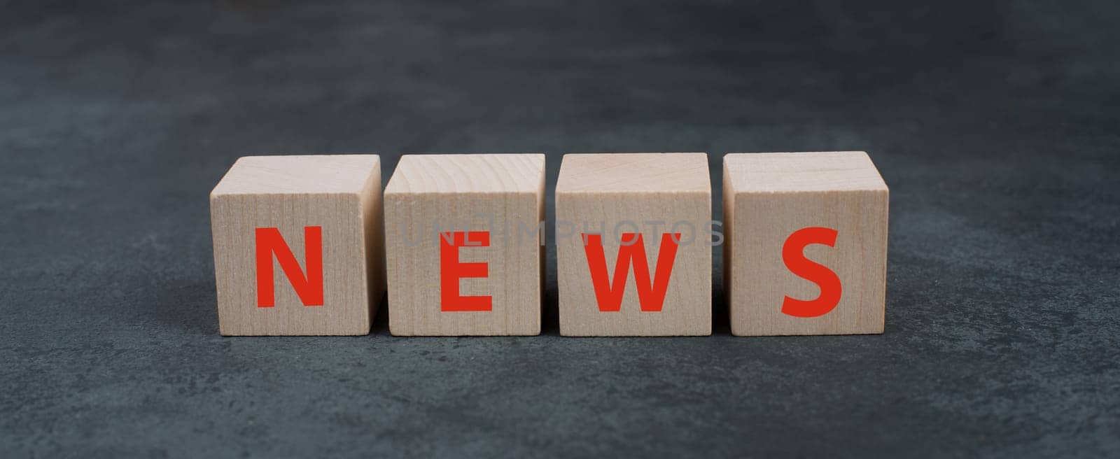 The word news is standing on wooden blocks, red color