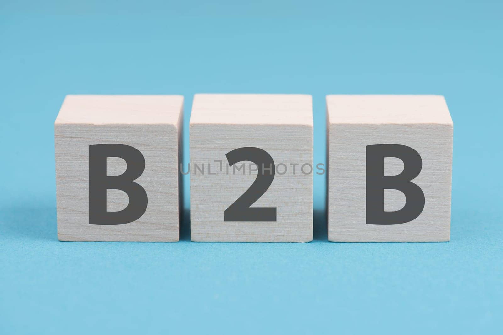 The word B2B is standing on wooden cubes, blue colored background