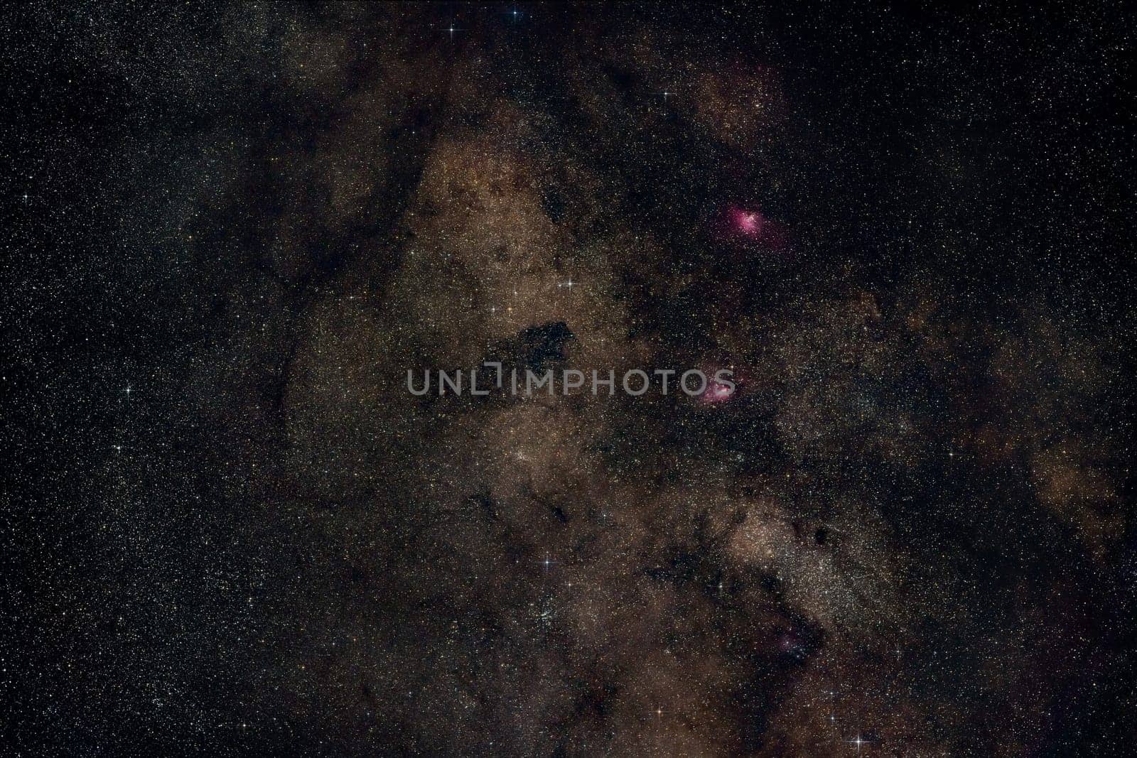 Night summer sky with milky way near Scutum constellation, bright Sagittarius clouds, purple Eagle and Swan nebula visible. Long exposure stacked photo.