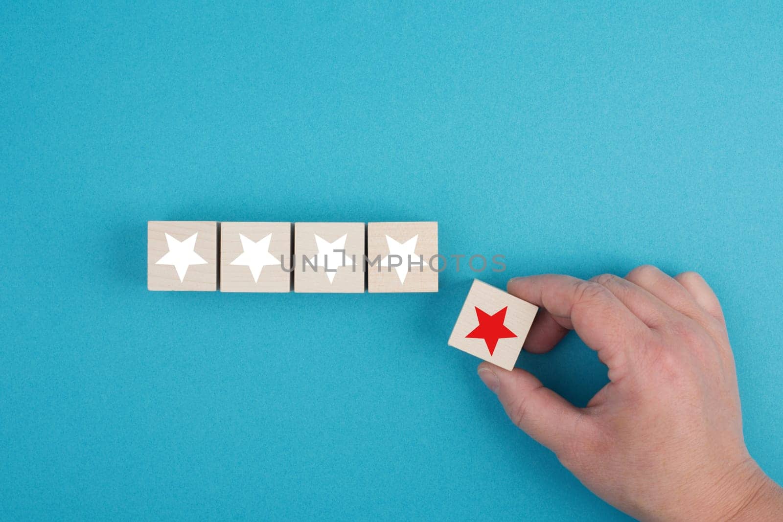 Wooden cubes with white stars, one block with a red star holding in the hand