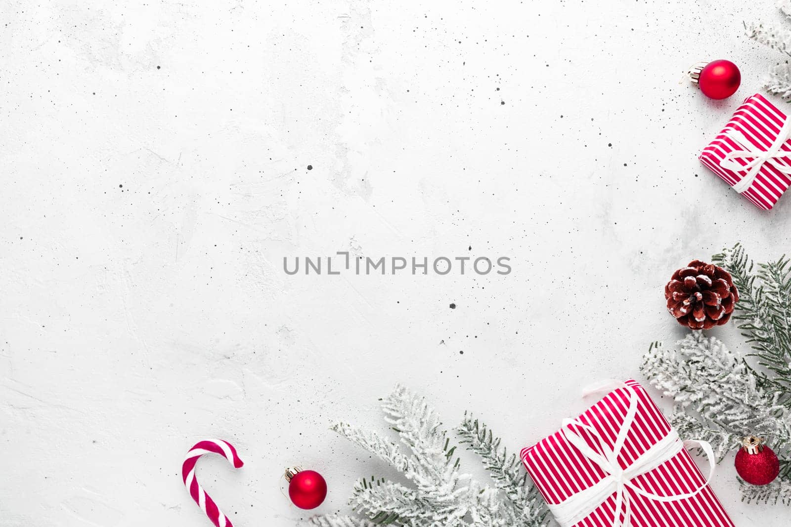 Christmas, New Year gray concrete flat lay with red white present gift boxes top view. Gift ribbon and packaging paper. Christmas tree fir, cones, toys, candy stick lolly, Copy space text area