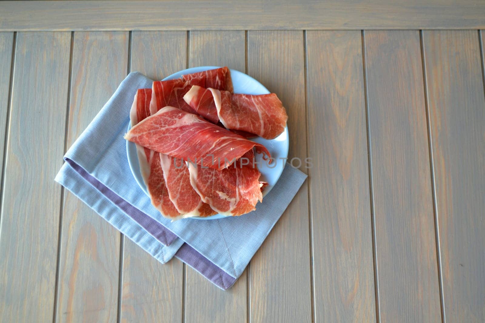 Pressed marbled meat cut in thin slices, fresh cold sliced bacon.