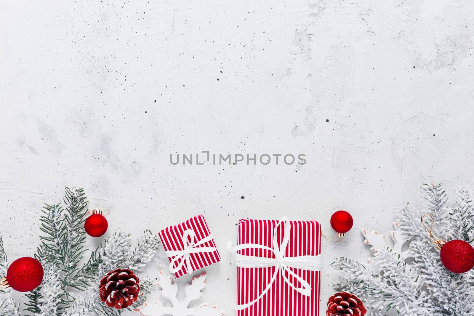 Christmas, New Year gray concrete flat lay with red white present gift boxes top view. Gift ribbon and packaging paper. Christmas tree fir, cones, toys. Copy space text area on high quality photo