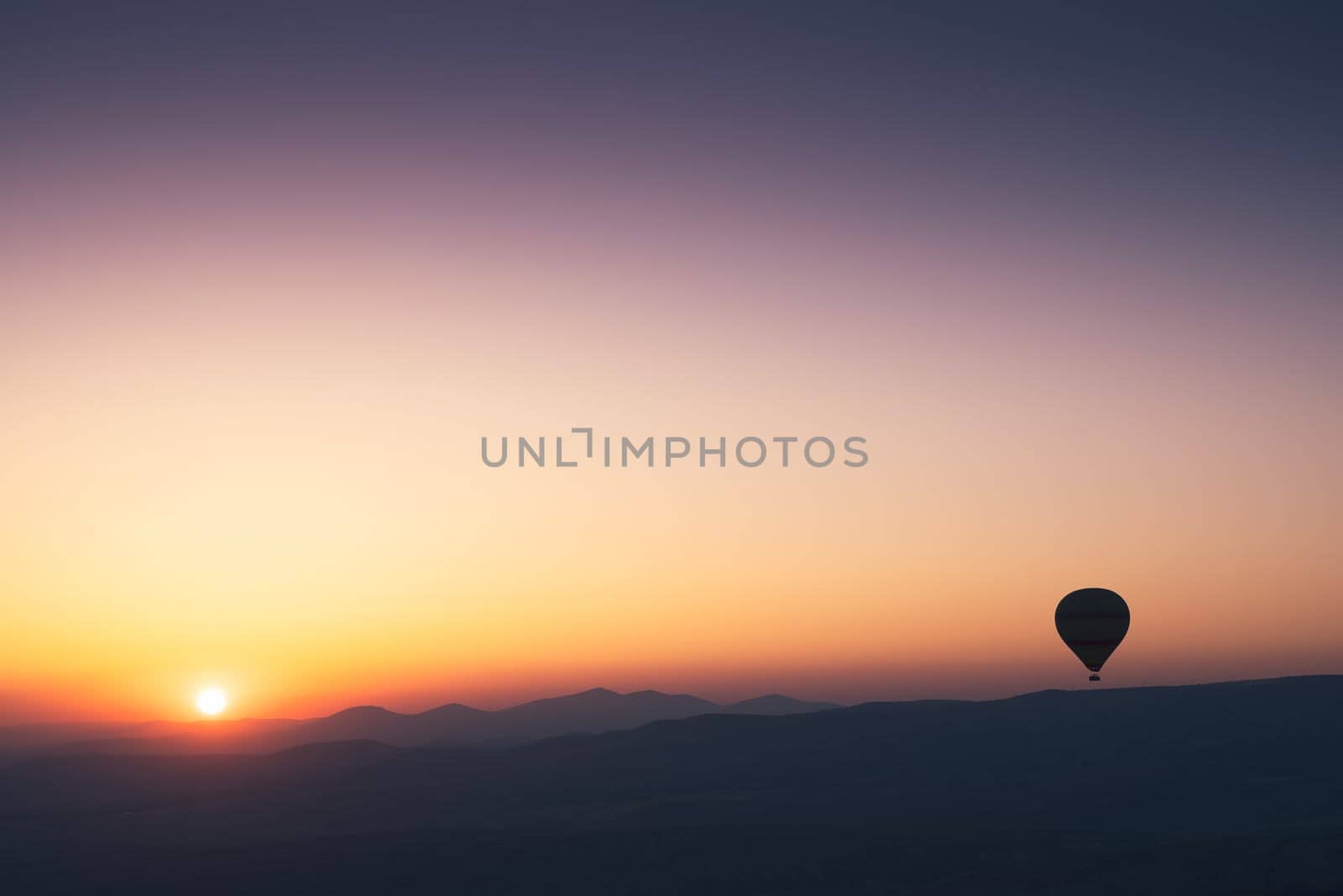 landscape with hot air balloons black silhouette rising up to the sky at sunrise with beautiful high mountain panorama in the background