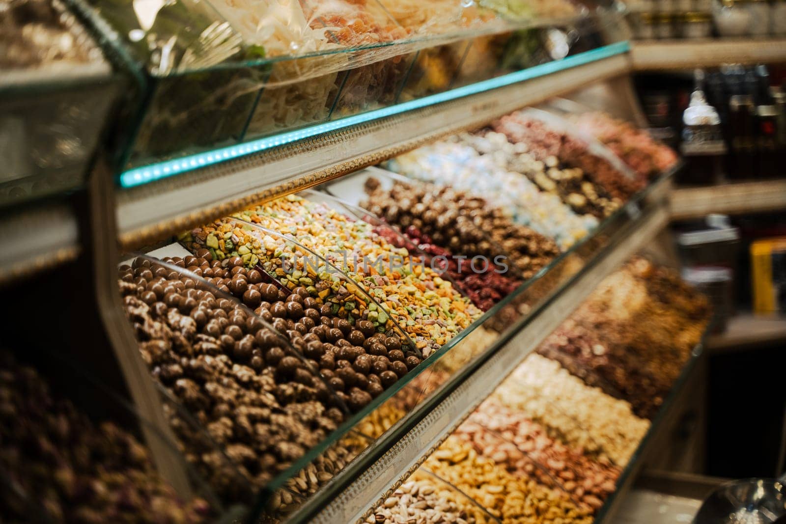perspective view closeup of rows of assorted chocolate candy assortments lined up in the window of a sweet shop