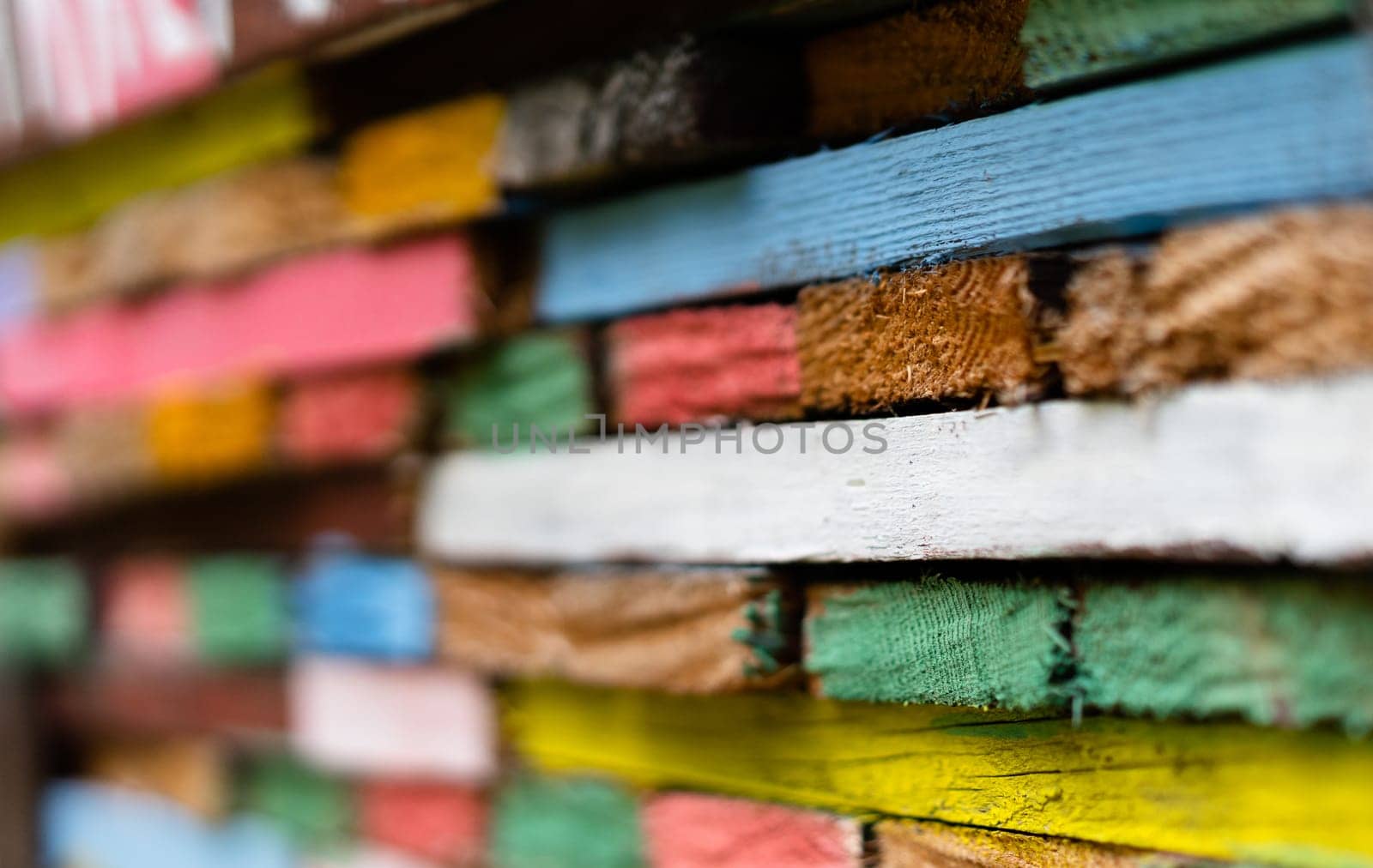 closeup perspective view of stacked wooden planks decorated with paint in different colors
