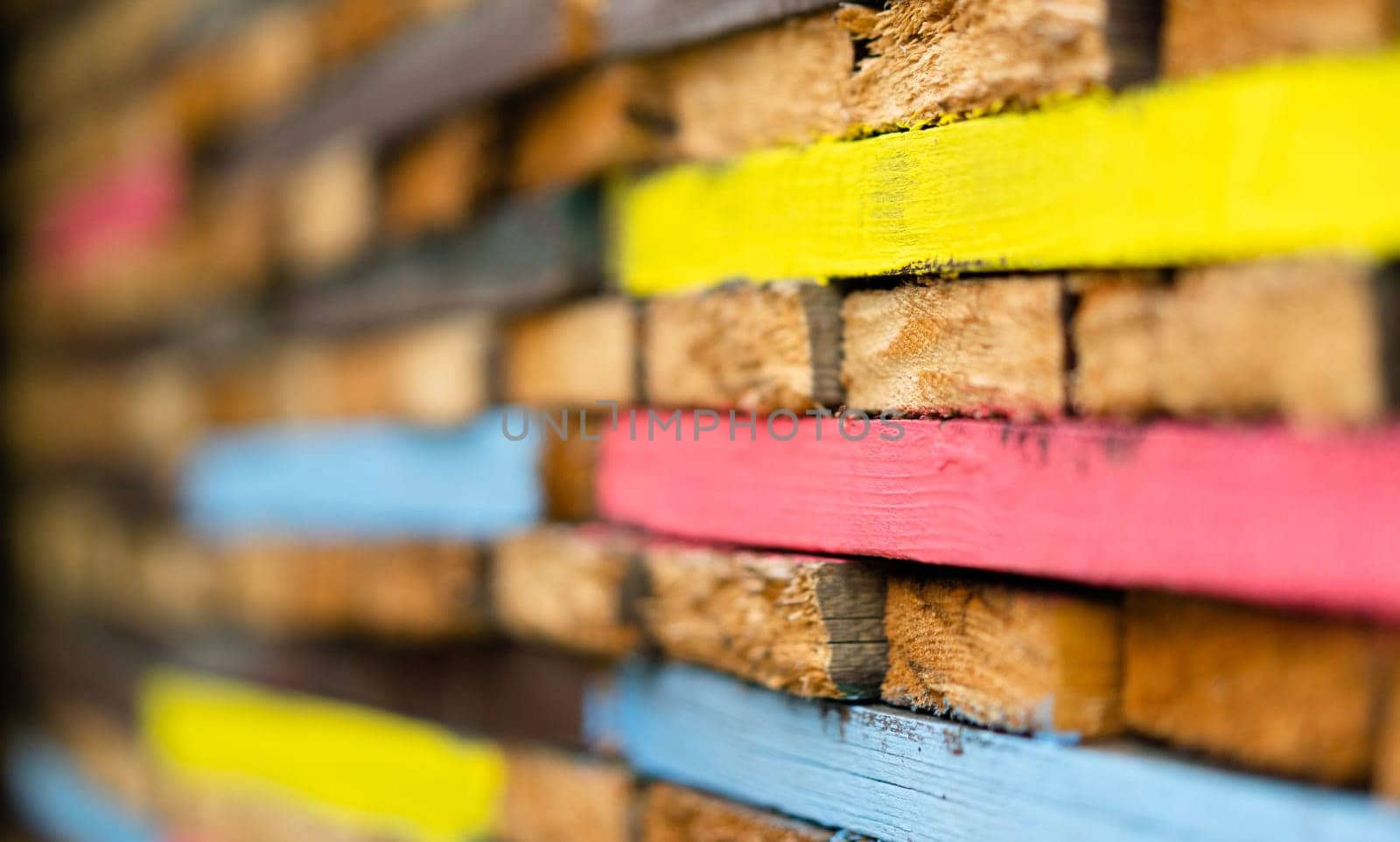 closeup perspective view of stacked wooden planks decorated with paint in different colors
