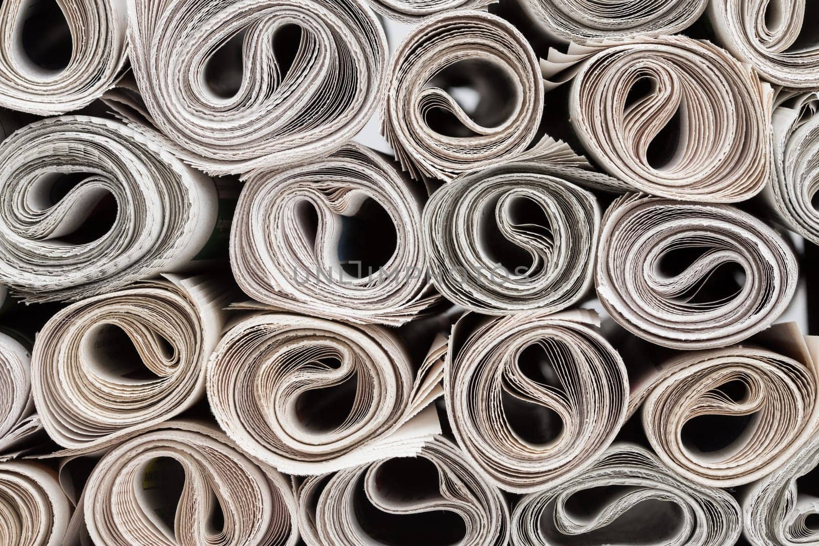 Stack of newspapers rolls, paper texture background.