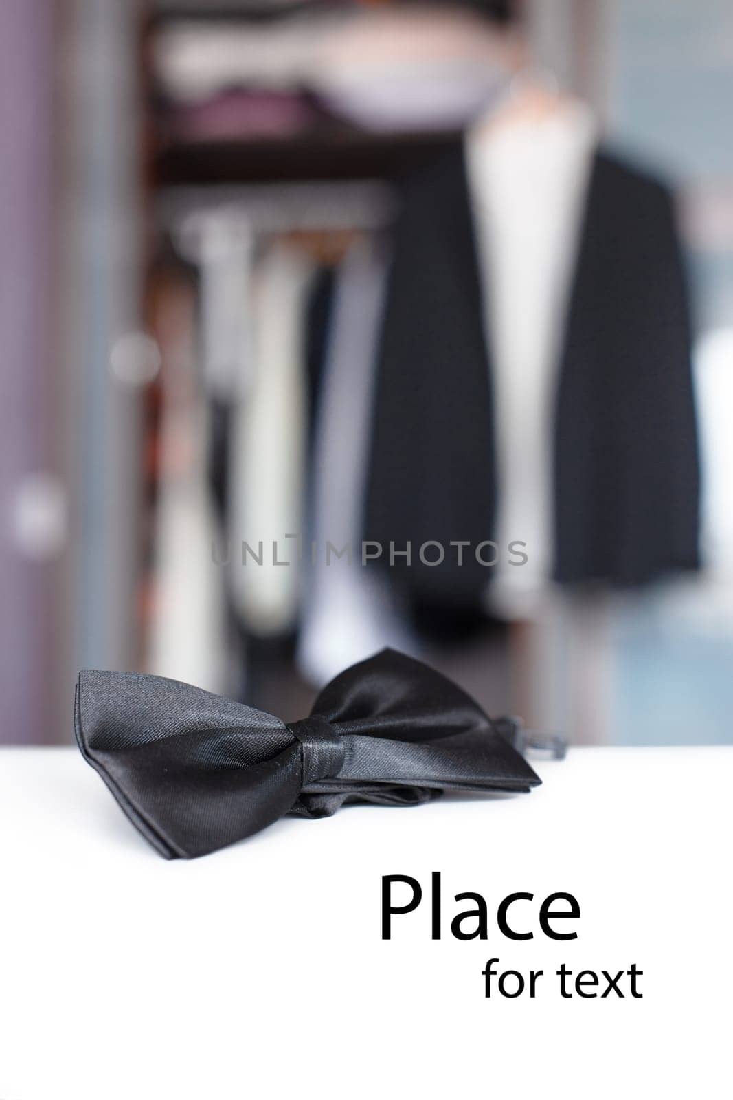 Bow tie with open closet and tuxedo. Getting ready for formal night. With isolated place for text.