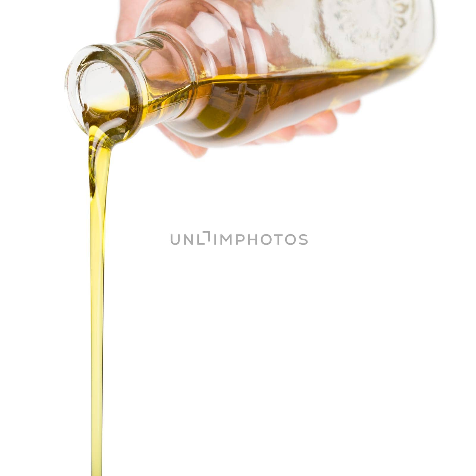 Male hand holding a bottle. Oil pouring from a bottle.