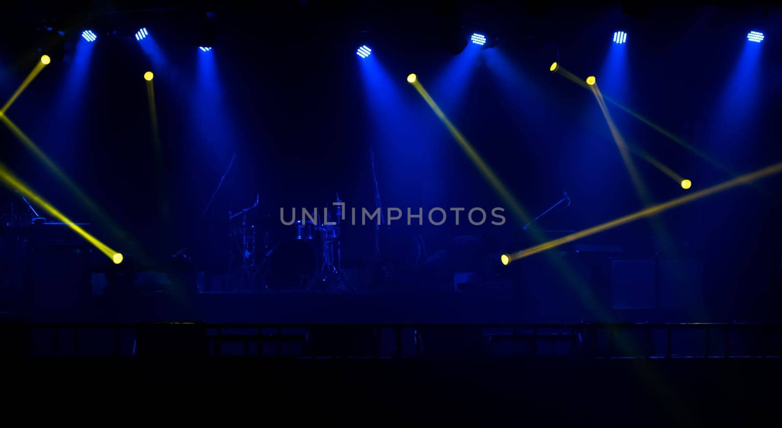 Blue and yellow stage spotlights with smoke. Floodlights of concert scene