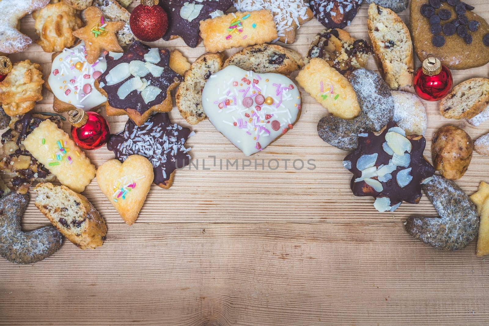 Homemade Christmas cookies, powdered sugar and Christmas bauble on a rustic wooden table. Copy Space.