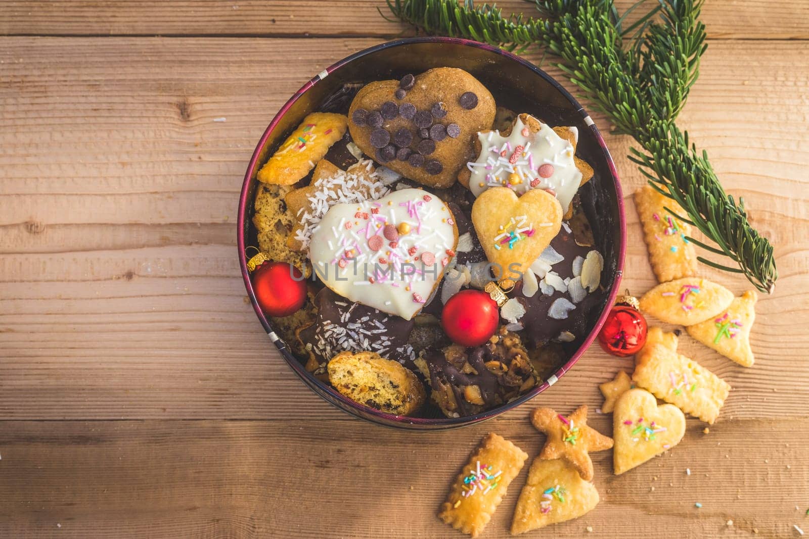 Homemade Christmas cookies, powdered sugar and Christmas bauble on a rustic wooden table