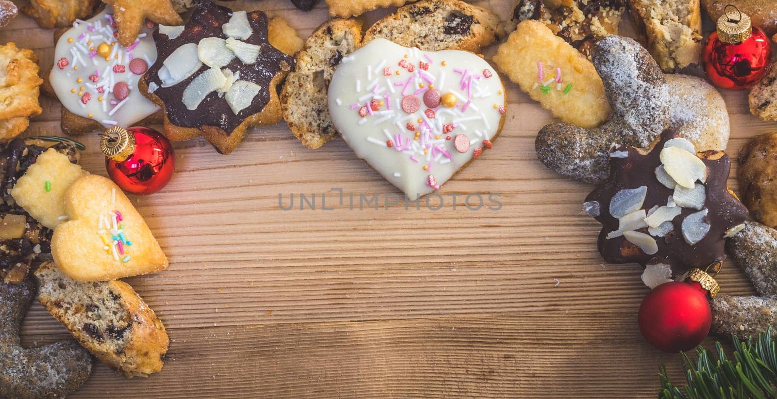 Homemade Christmas cookies, powdered sugar and Christmas bauble on a rustic wooden table. Copy Space.