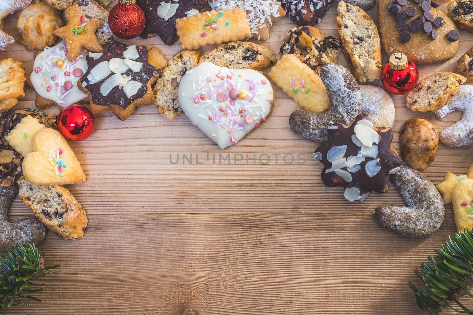 Homemade Christmas cookies, powdered sugar and Christmas bauble on a rustic wooden table. Copy Space.