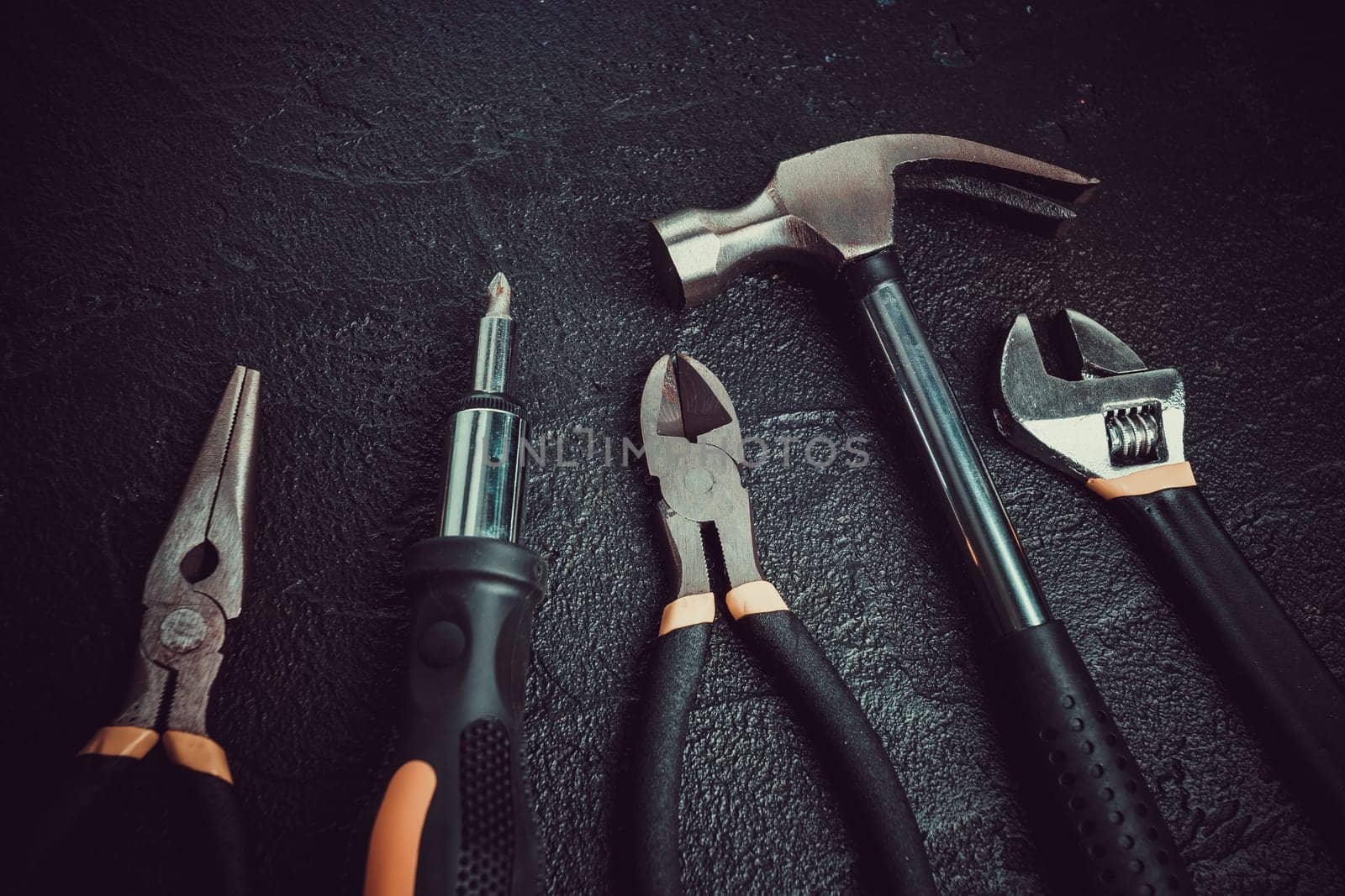 Many different tools for repair work on a black background