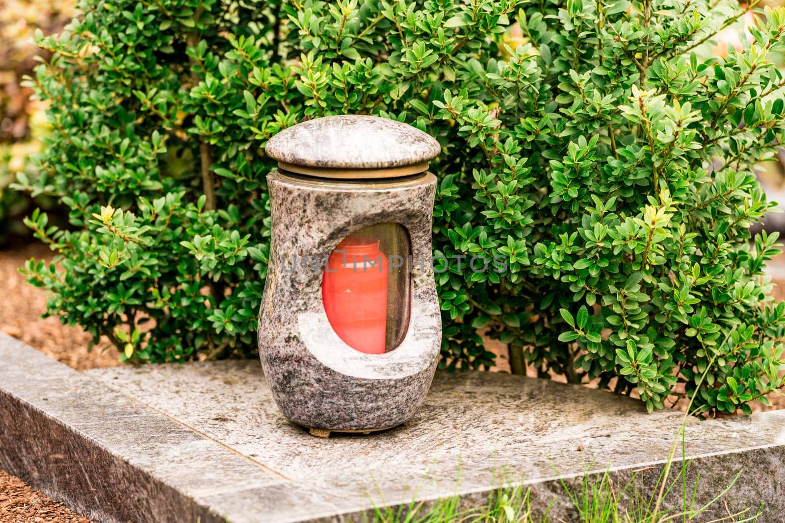 Old damaged grave lantern on a gravestone