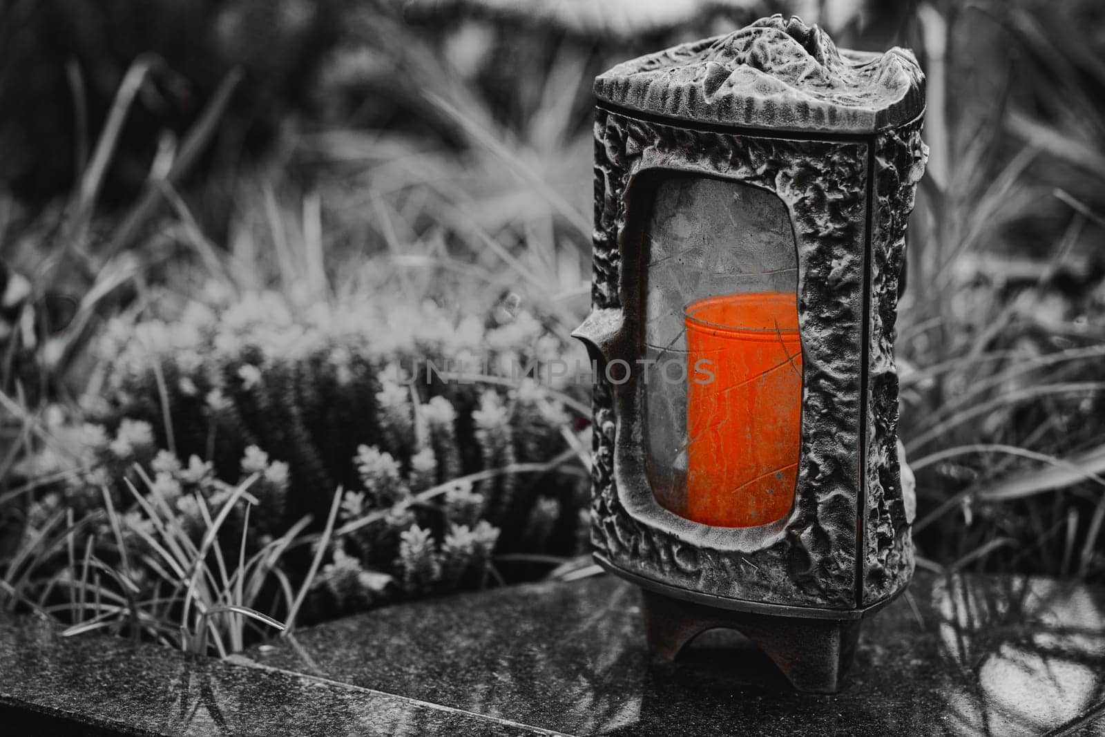 Old damaged grave lantern on a gravestone