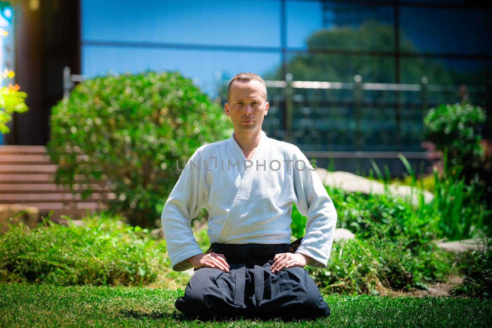 Young serious man aikido master in traditional costume