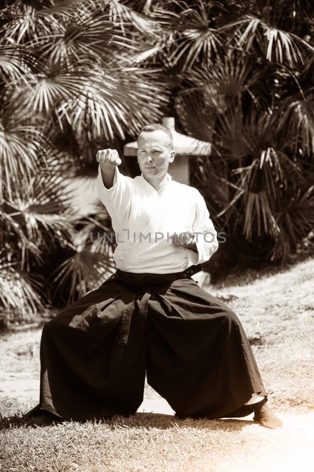 Young serious man aikido master in traditional costume