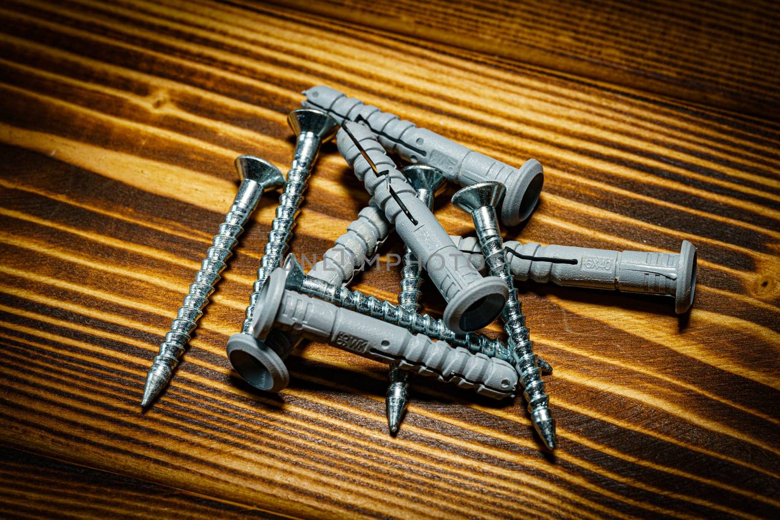 Closeup shot of a row of screws laid on a wooden table