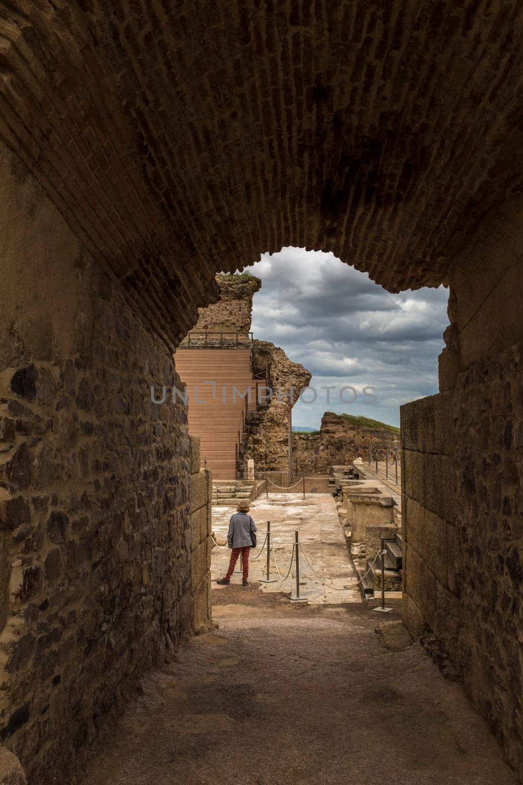 Medellin, Spain - April 28th, 2018: Roman theatre of Medellin. Visitor woman under side arch entry, Extremadura, Spain