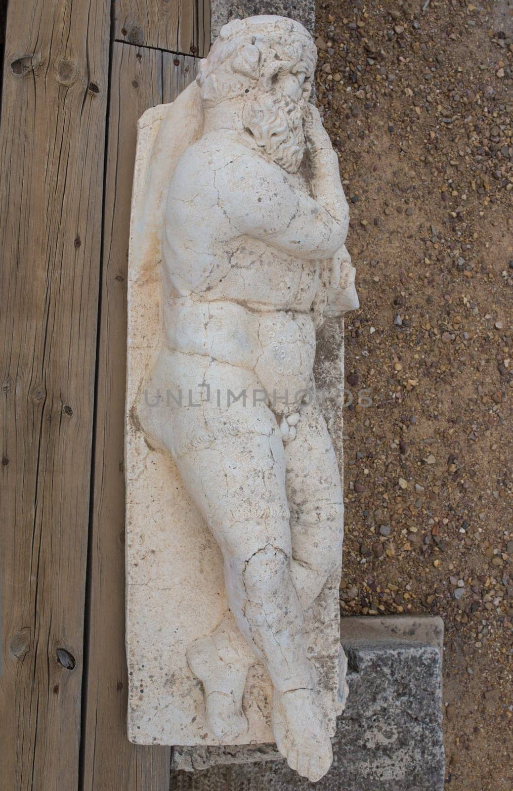 Medellin, Spain - April 28th, 2018: Old man holding an amphora. Statue-shaped fountain. Roman theatre of Medellin, Extremadura, Spain. Overhead view
