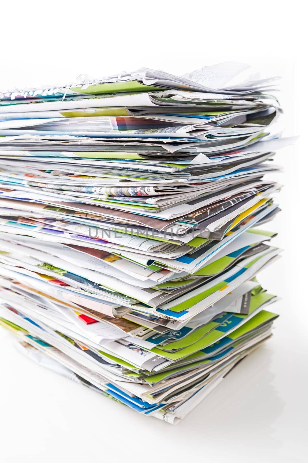 Stack of waste paper, old magazines, newspapers and leaflets for recycling isolated on white