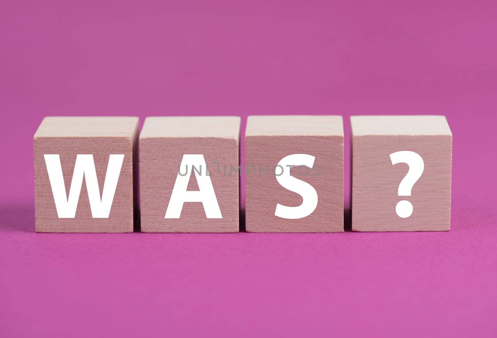 The german word for what is standing on wooden cubes, pink colored background