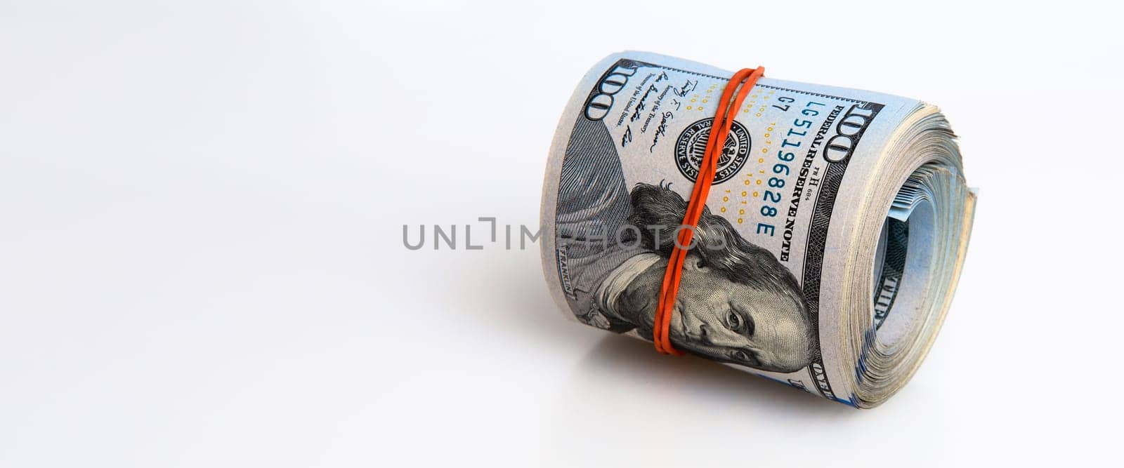 A roll of dollars on a white background. One hundred American dollar bills. Place for logo, lettering, layout.