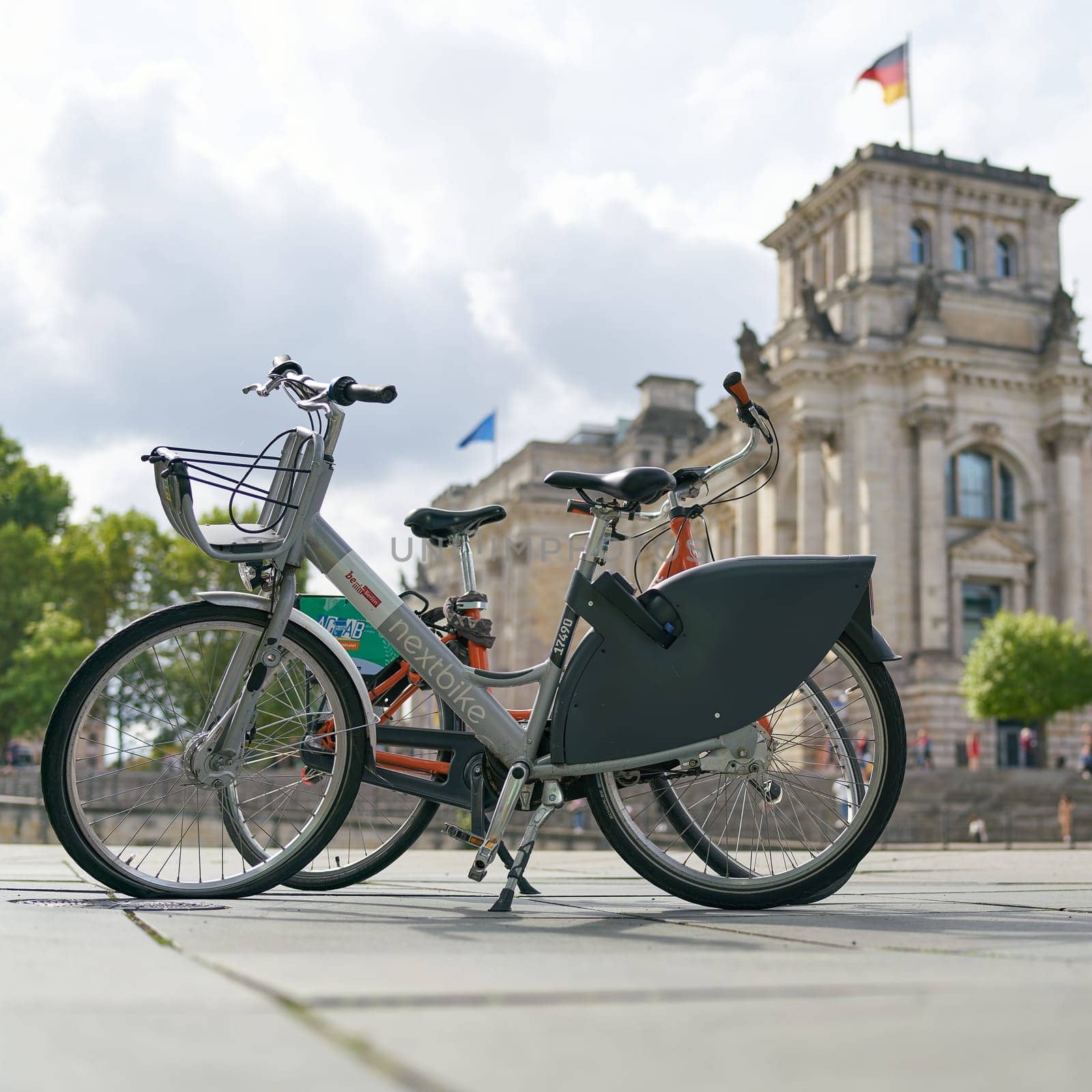Bicycle of the public bicycle rental system of the city of Berlin Nextbike in the government district. In the background the Reichstag.
