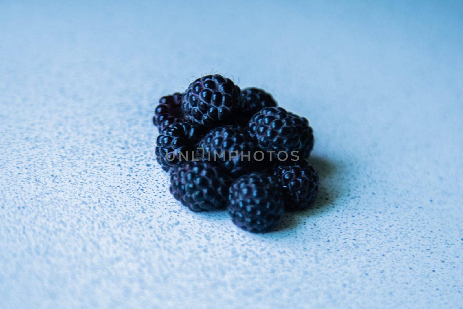 BlackBerry berries stacked in a pyramid on a light background. High quality photo