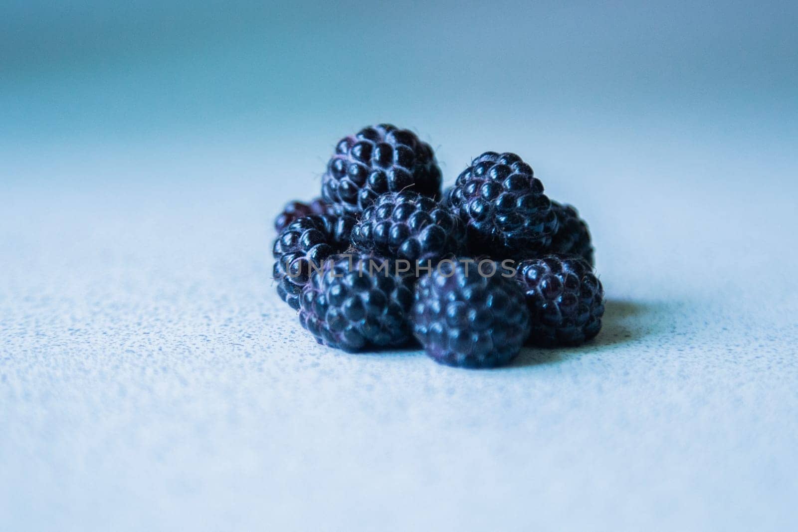 BlackBerry berries stacked in a pyramid on a light background. High quality photo