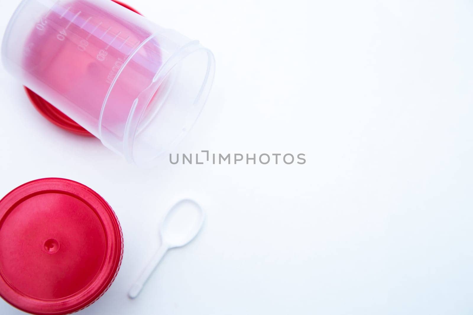 Jars for collecting tests with a red lid and a spoon on a white background. . High quality photo