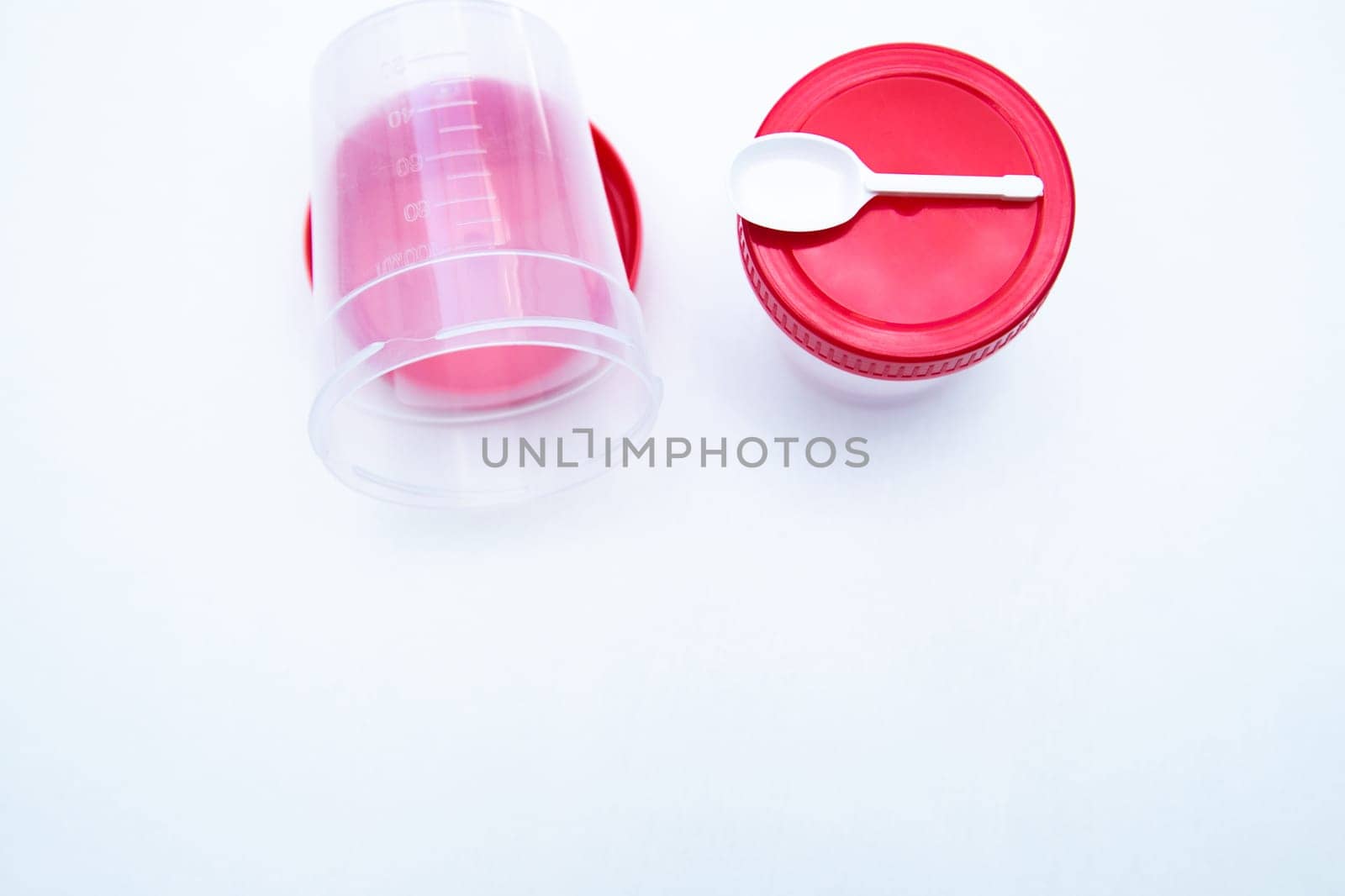 Jars for collecting tests with a red lid and a spoon on a white background. . High quality photo