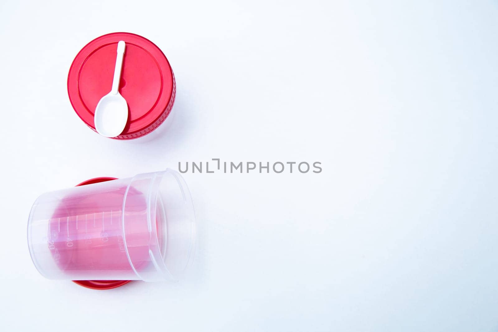 Jars for collecting tests with a red lid and a spoon on a white background. . High quality photo