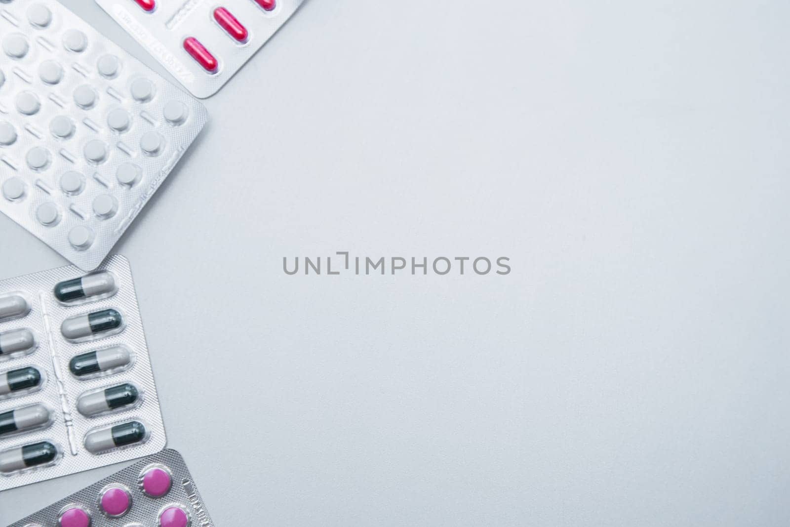 tablets and capsules in the package lie on the side on a white background with a place for text in the middle. High quality photo