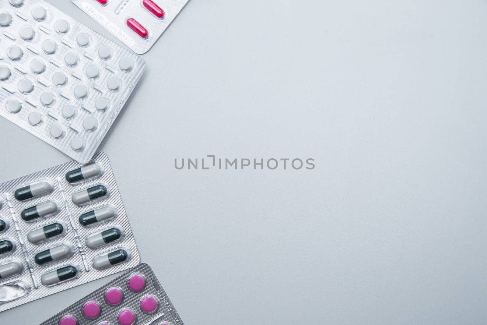 tablets and capsules in the package lie on the side on a white background with a place for text in the middle. High quality photo