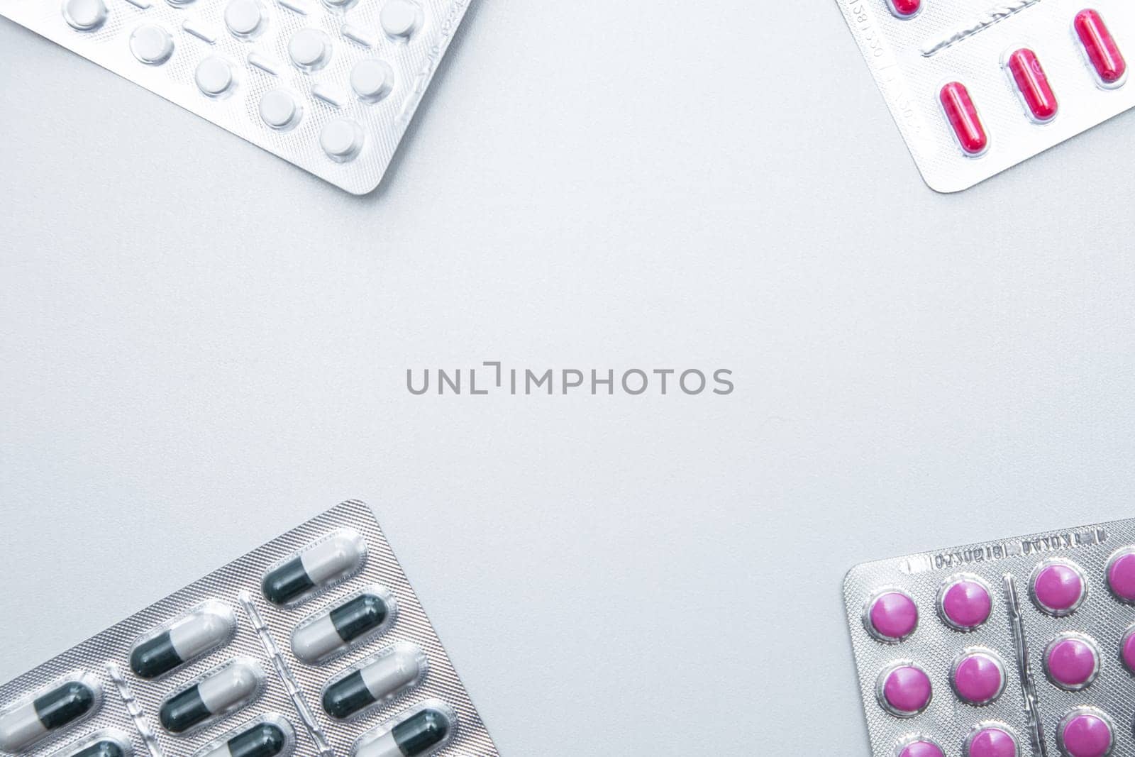 tablets and capsules in the package are in the four corners of the photo with a place for the text in the middle. . High quality photo