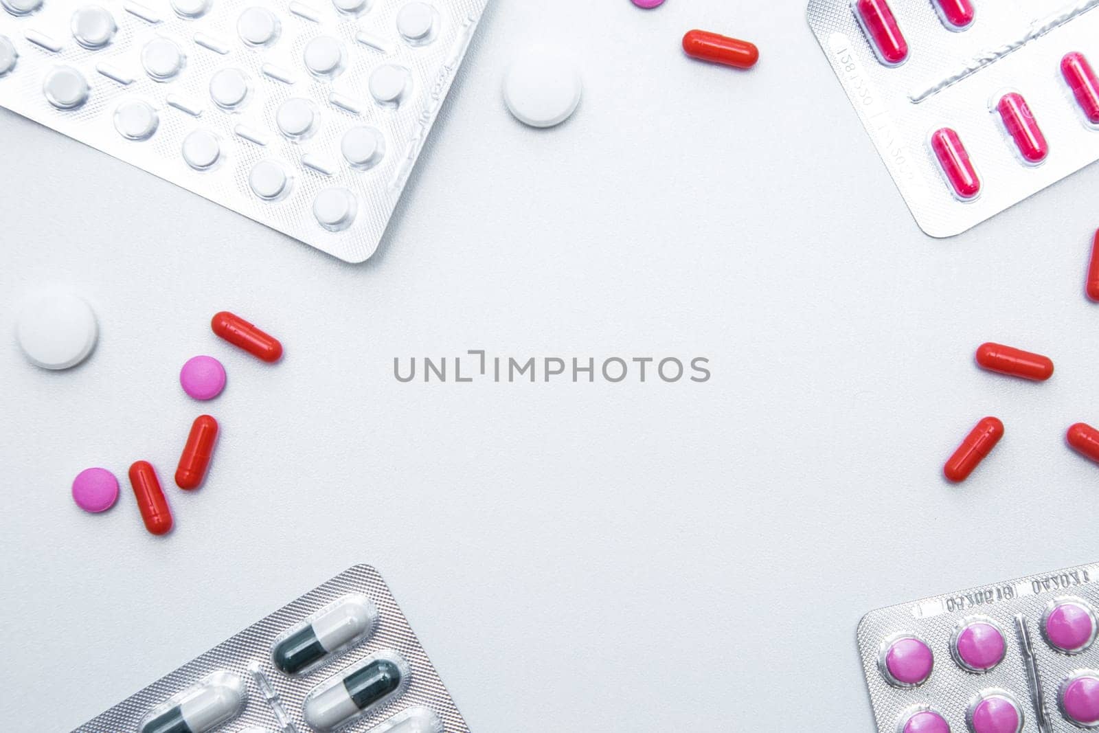 Packages and tablets are on the sides of photos with handfuls of tablets and capsules on the sides on a white background with a place for text in the middle. High quality photo