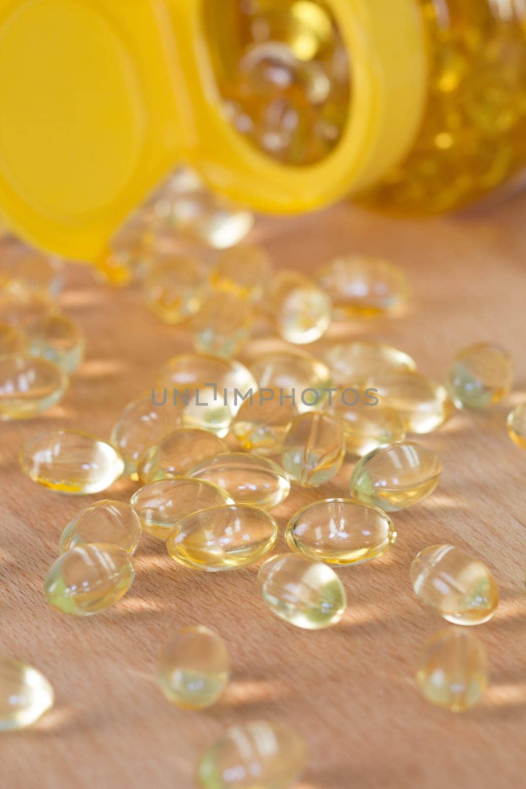 Fish oil omega pills spilled from an apothecary plastic bottle.