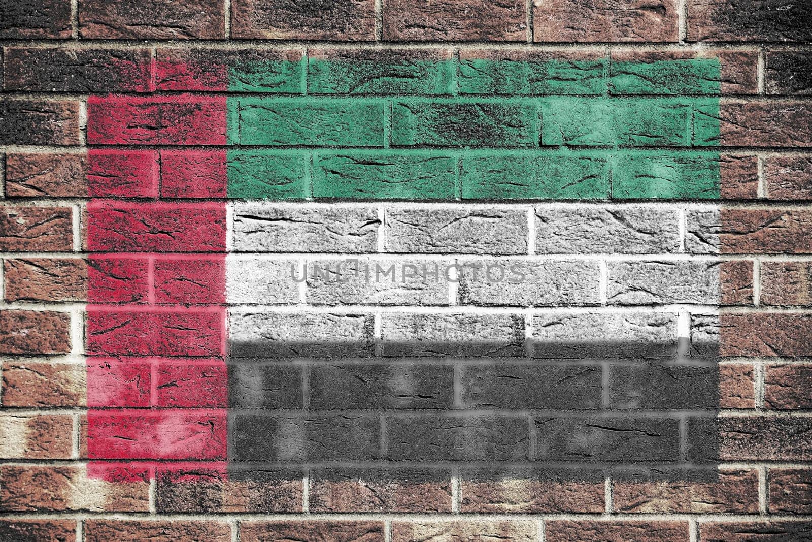 A United Arab Emirates flag on a brick wall background