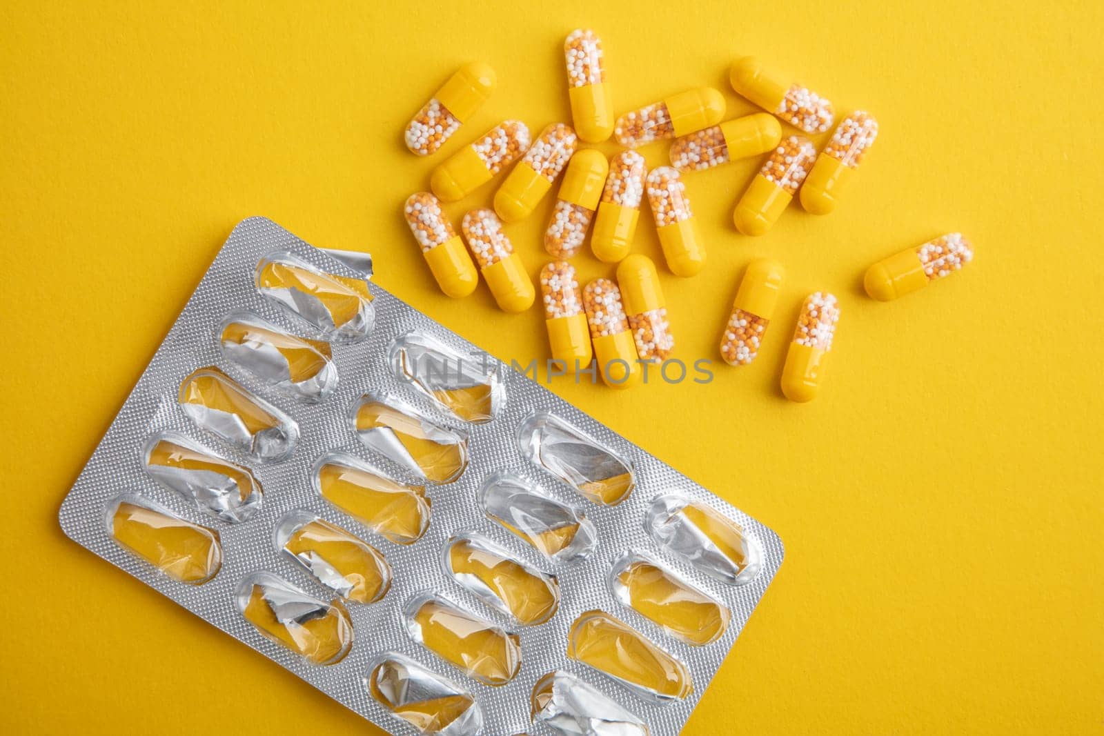Empty blister and pills on a yellow background