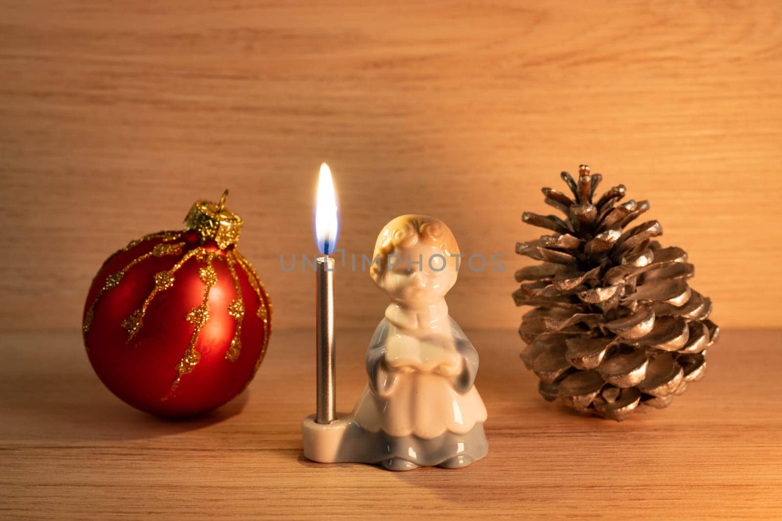 Christmas concept with altar boy candle holder, bauble and pine cone close up