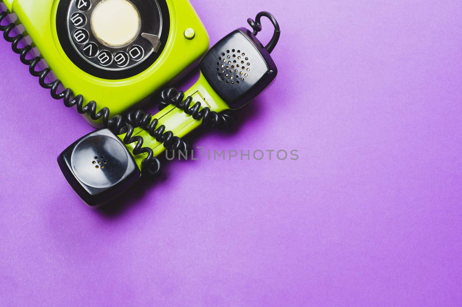 Classic phone with handset. vintage green telephone with phone receiver isolated on purple background. old communication technology. copy space