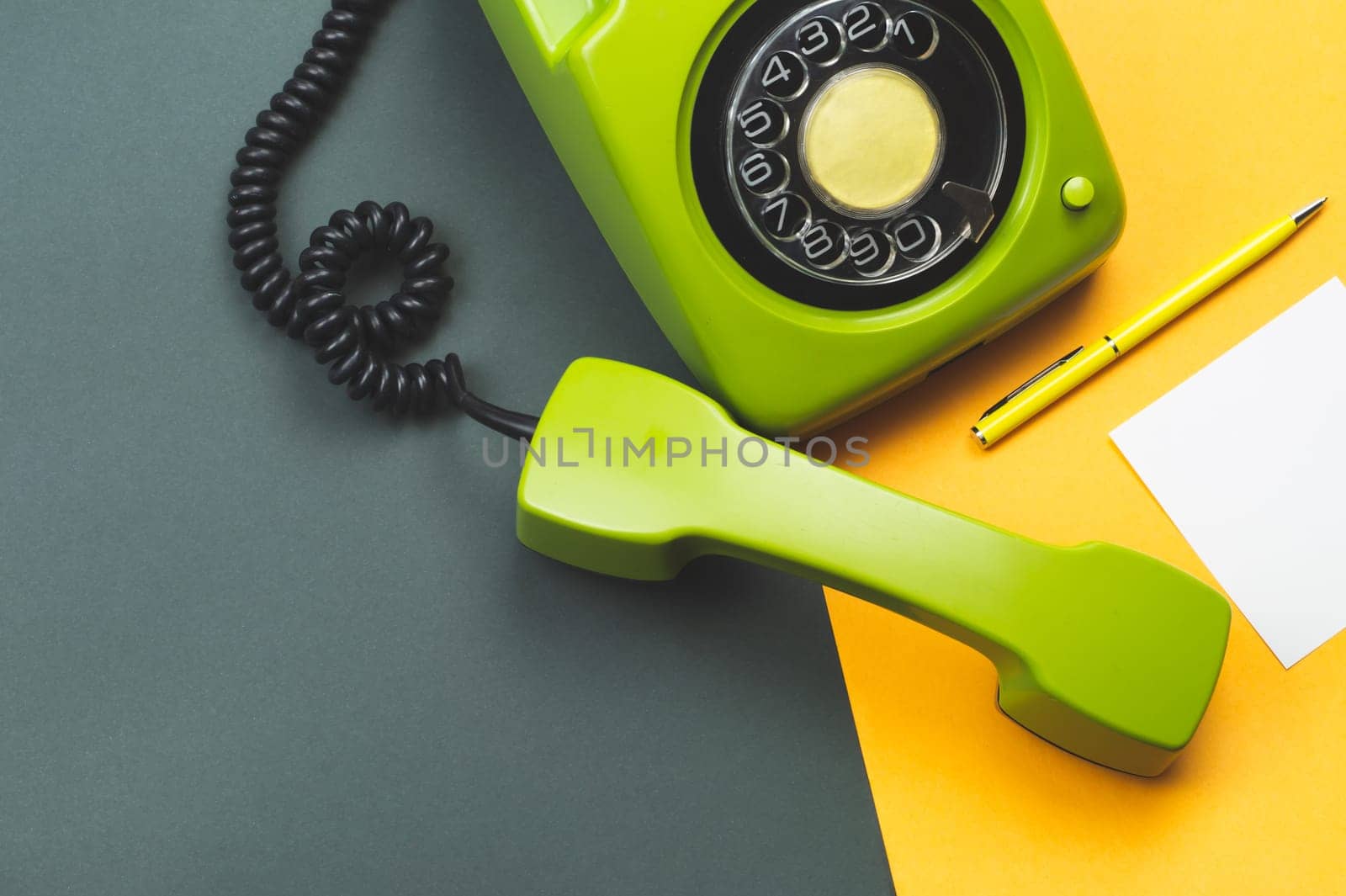 Classic phone with handset. pen with a note. office background. vintage green telephone with phone receiver. old communication technology. copy space